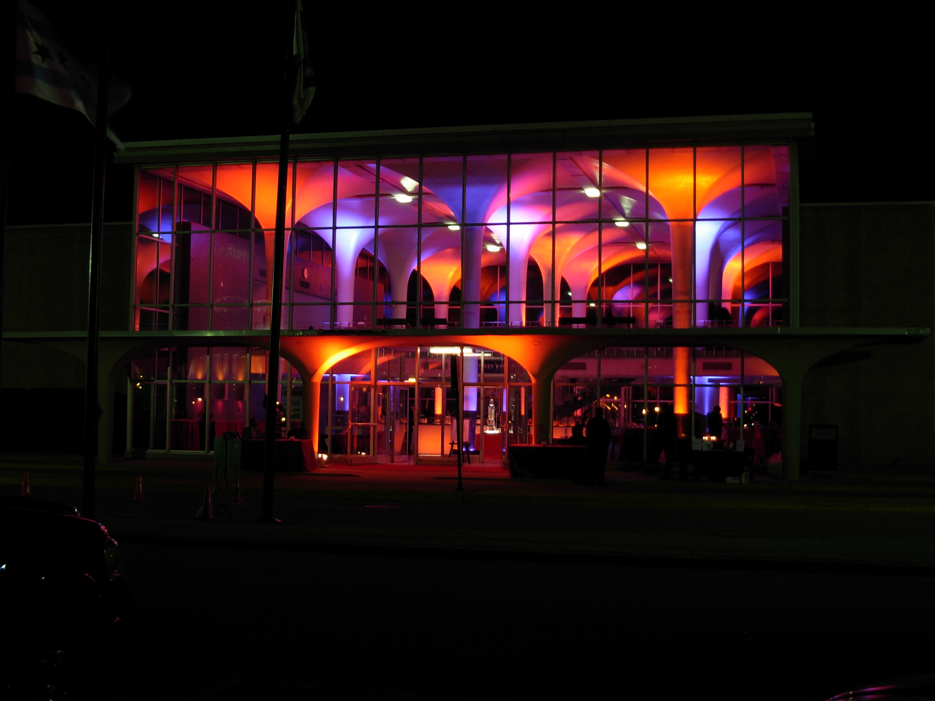 Building with orange and purple interior lights visible through large glass windows at night.