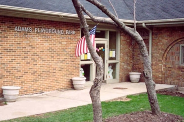 Adams Playground Park building exterior with US flag.