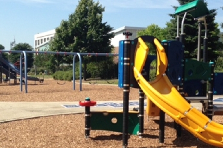 Colorful playground with slides and swings on a sunny day.
