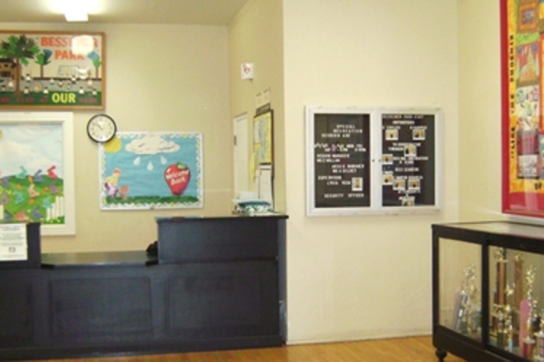 Reception area with bulletin boards, information board, and trophy case.