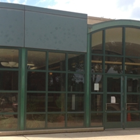 Ada Park building exterior with green-framed windows and doors.