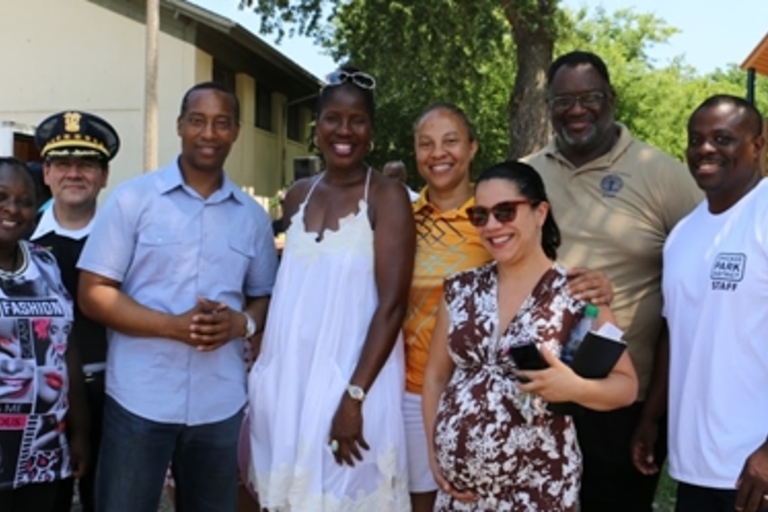 Group photo of adults smiling at a park.
