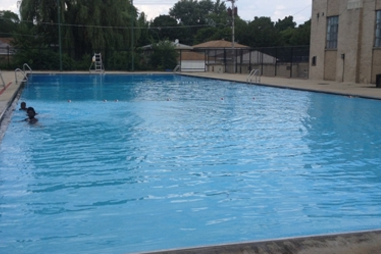 Children swimming in a large outdoor pool.