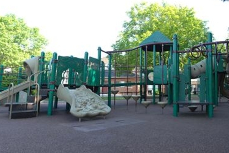 Green playground structure with slides and climbing features.
