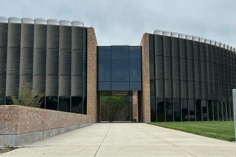 Modern building with textured metal facade and glass entrance.