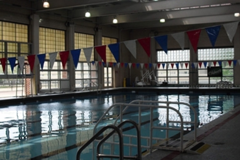 Indoor swimming pool with red, white, and blue pennant banners.