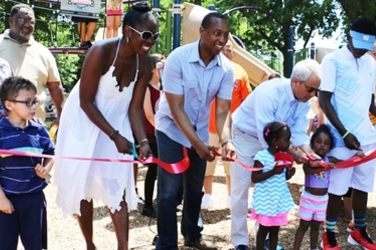 Ribbon-cutting ceremony at a playground.
