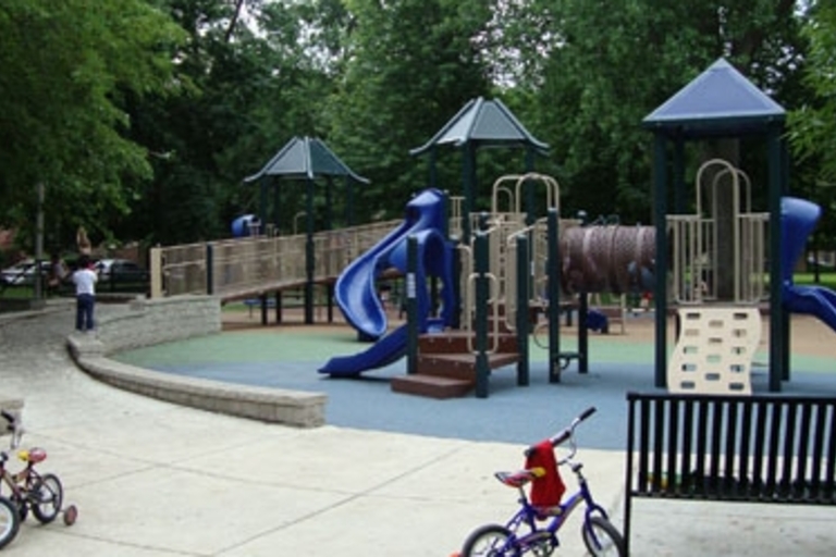 Playground with blue slides and two parked bikes.
