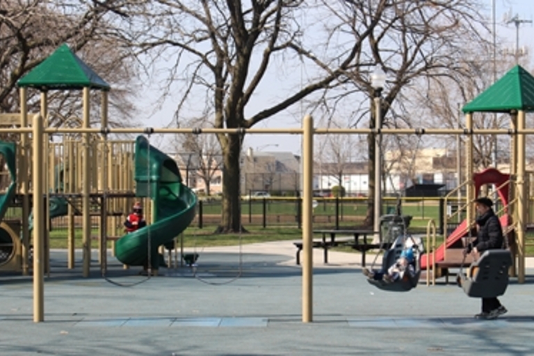 Children play on swings and slides at a playground.