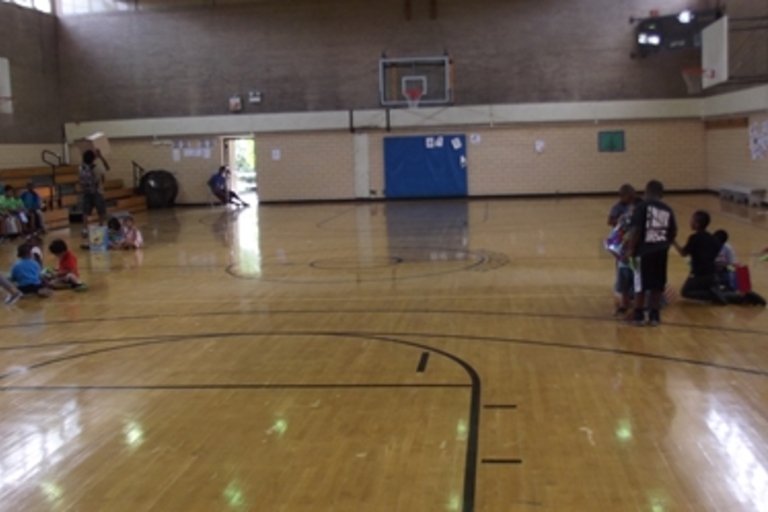 Children gather on a gym floor.