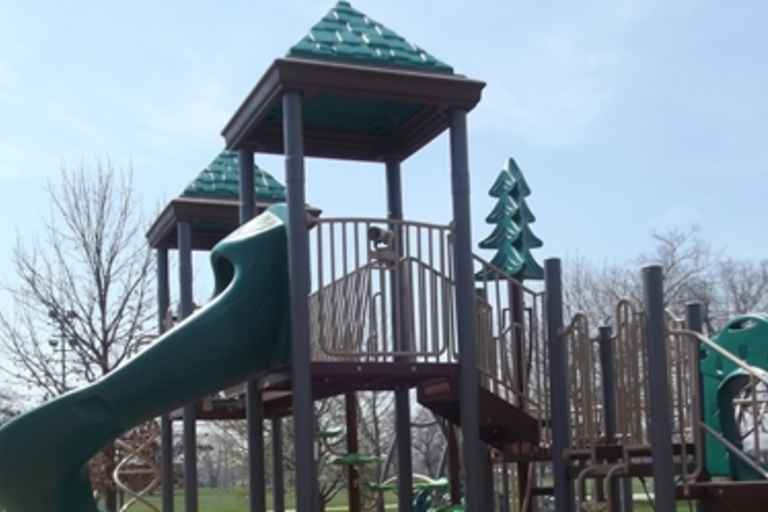 Green and brown playground slide and climbing structure.