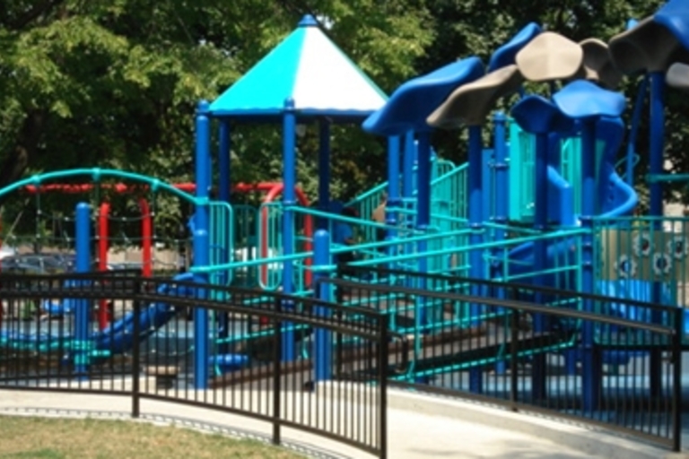 Accessible playground with ramps and slides in blue and teal.