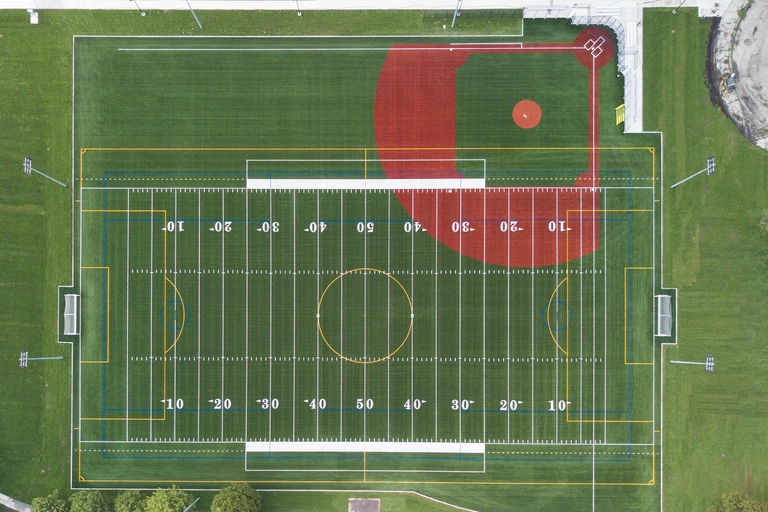 Aerial photograph of a multi-sport field with football and baseball markings.