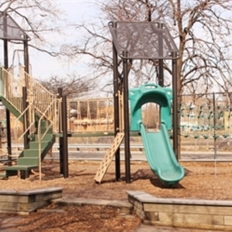 Playground with two green slides and climbing structures.
