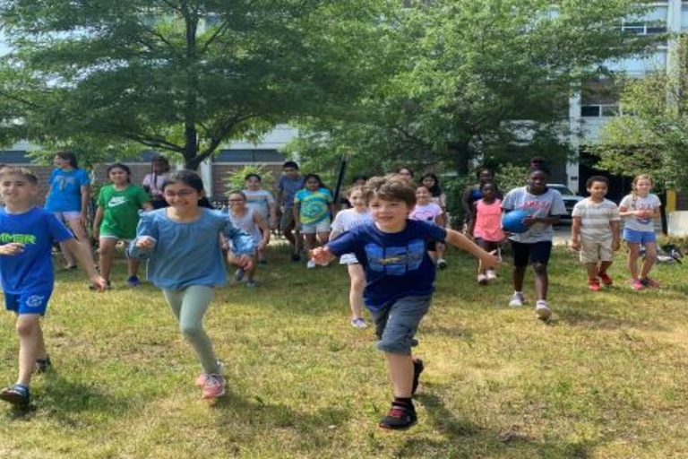 Children running on a grassy field.
