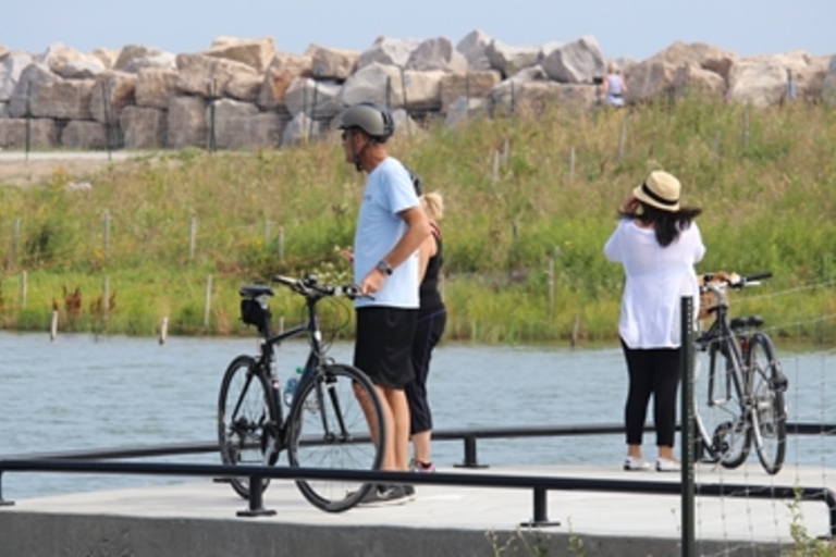Cyclists pause on a waterfront pier.
