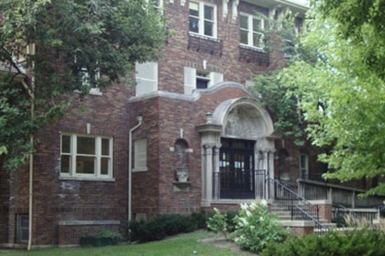 Brick building entrance with arched doorway and accessibility ramp.
