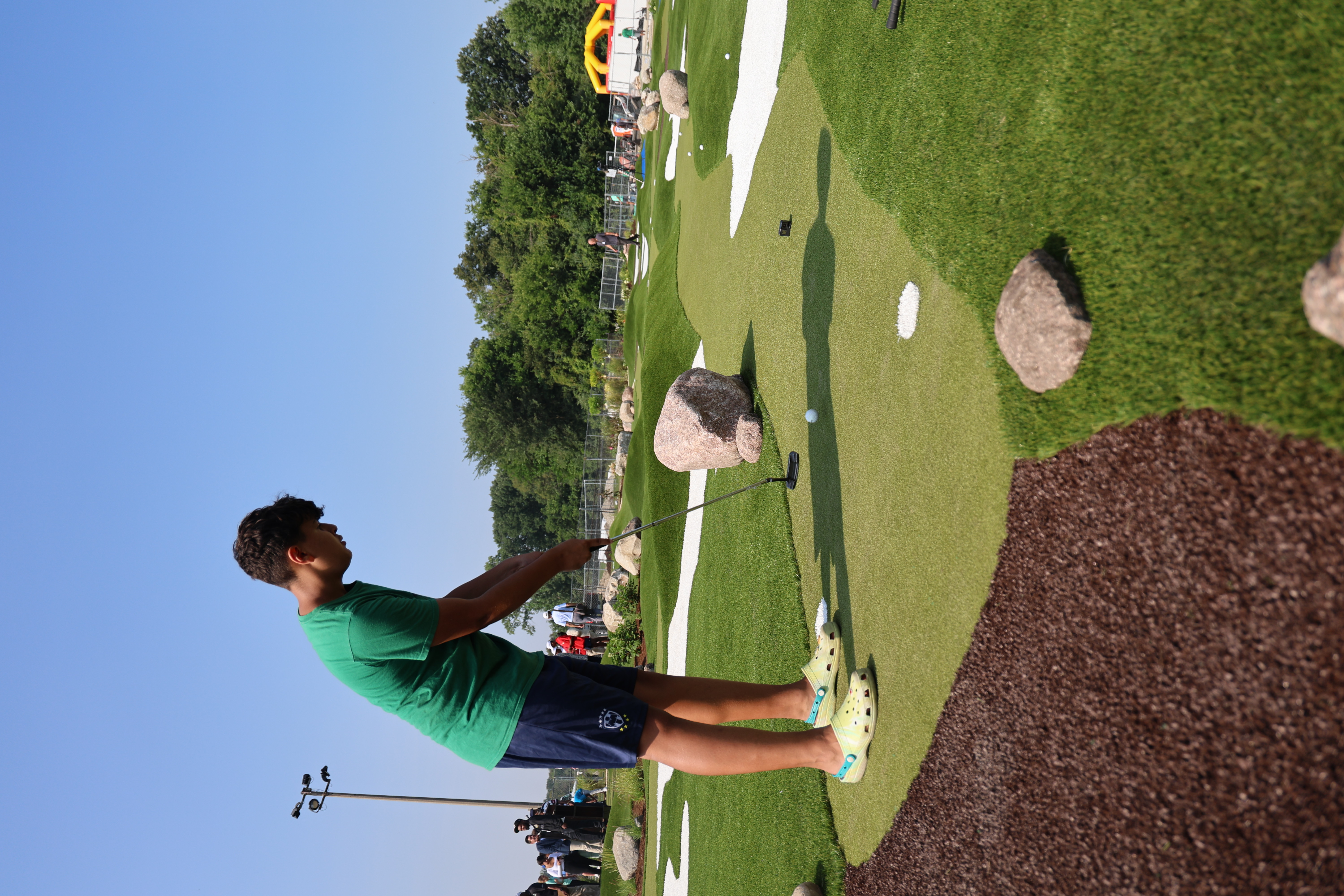 Teenager putting on a mini golf course.
