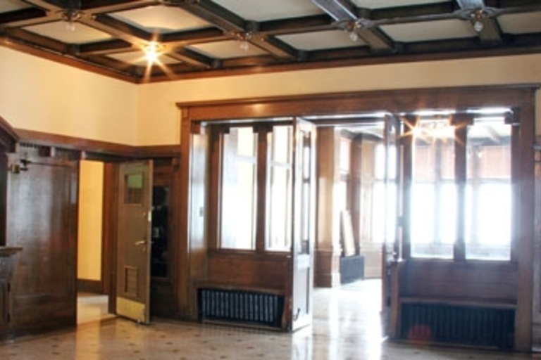 Grand entryway with dark wood paneling and coffered ceiling.