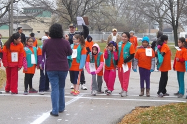 Girl Scouts at starting line of race in park.