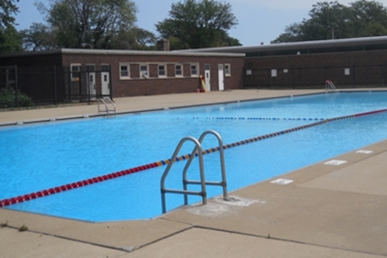 Outdoor swimming pool with lane dividers and metal ladder.