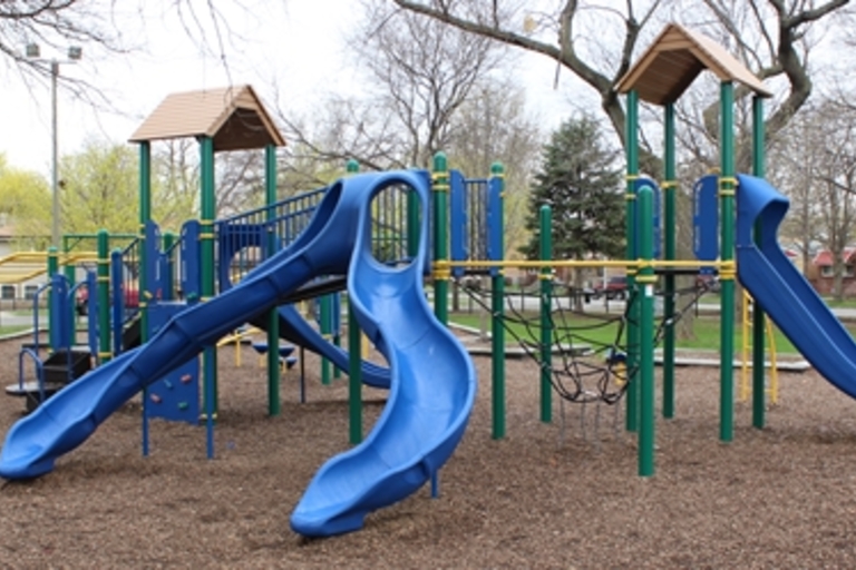 Colorful playground with blue slides and climbing structures.
