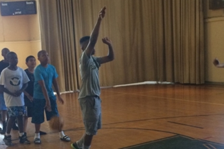 Kids playing basketball in a gym.