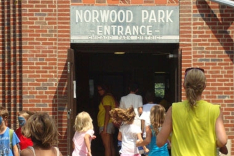 Children enter Norwood Park through a brick building's doorway.
