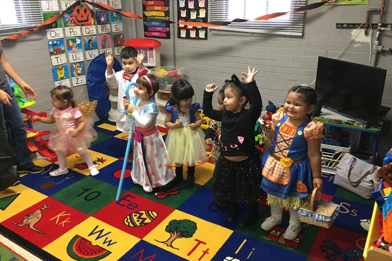 Children in Halloween costumes in a classroom.
