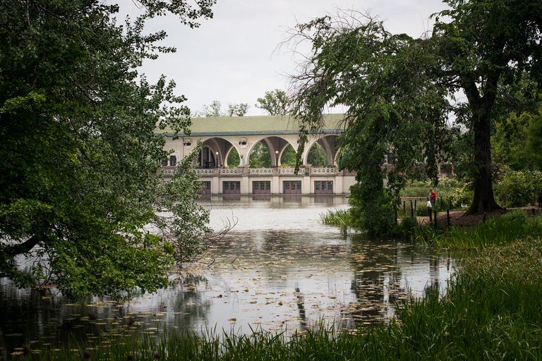 Boathouse on a lake, seen through trees.