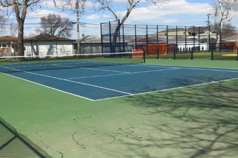 Empty blue and green tennis court on a sunny day.