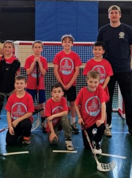 Youth floor hockey team poses for a photo.
