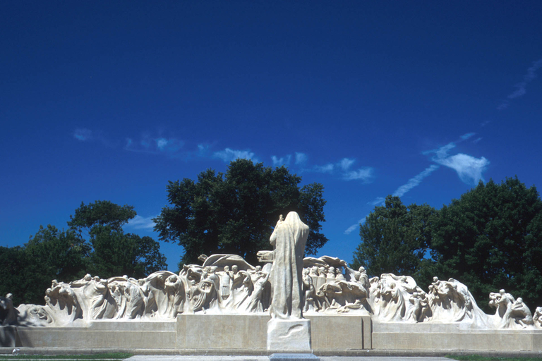 Large outdoor sculpture of robed figures, with a central robed figure facing away from the viewer.