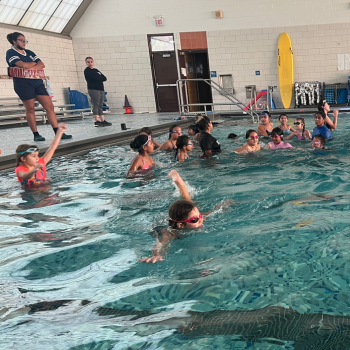 Youth enjoying swimming in an indoor pool.