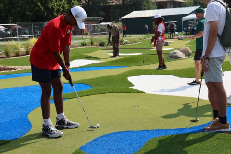 People putting on a colorful mini golf course.
