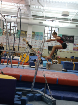 Gymnast performing on uneven parallel bars.