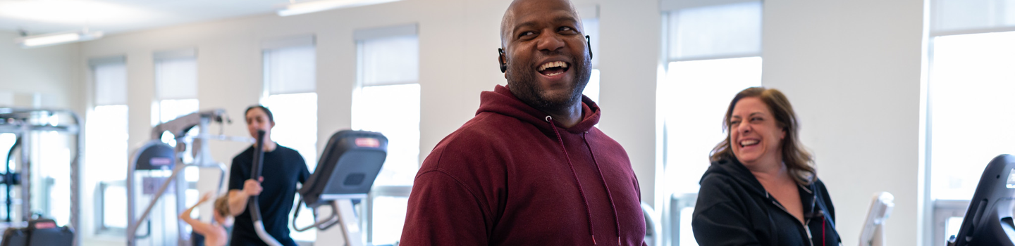 People laughing and exercising in a brightly lit gym.