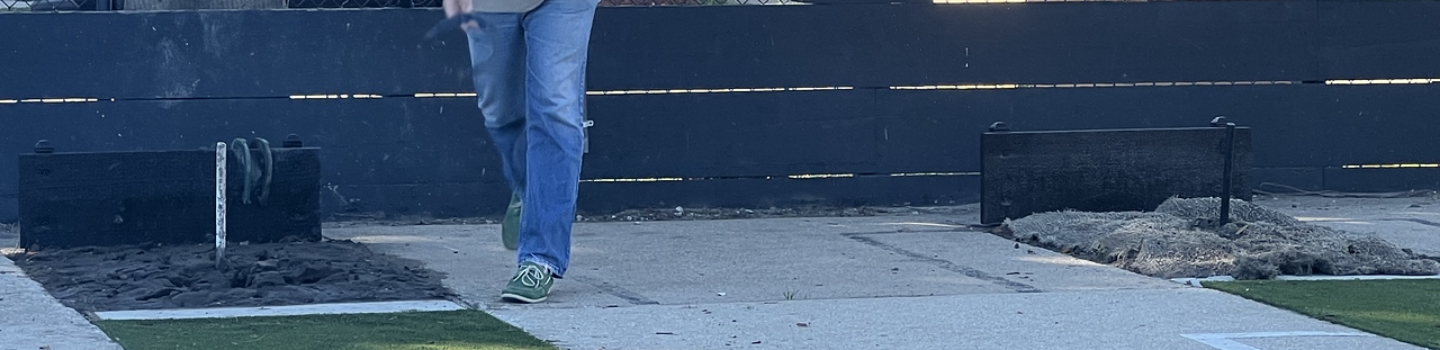 Person pitching horseshoes.