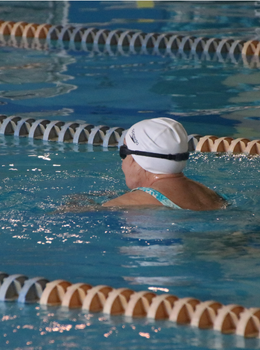 Woman swimming backstroke in a pool.