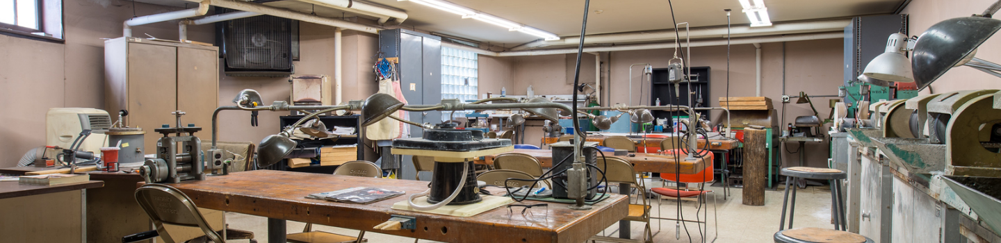 Jewelry studio workshop with workbenches, tools, and equipment.