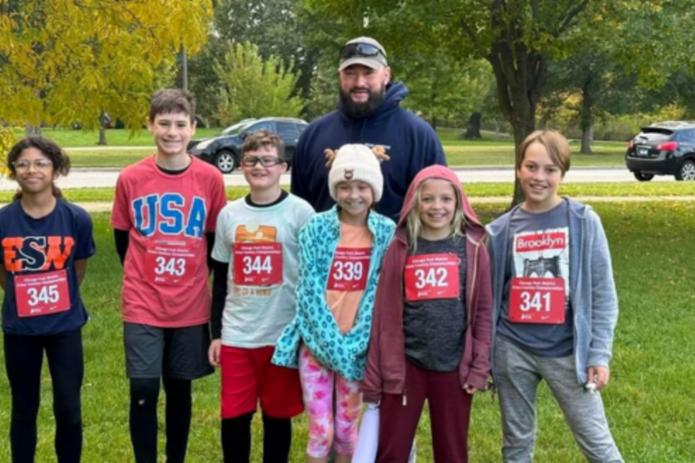Group photo of seven children and one adult wearing race bibs.