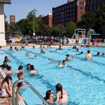Crowded public swimming pool on a sunny day.